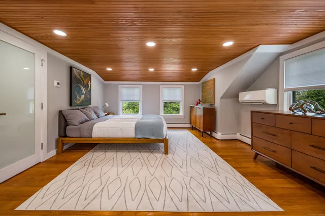 a spacious bedroom with a bed and a dresser