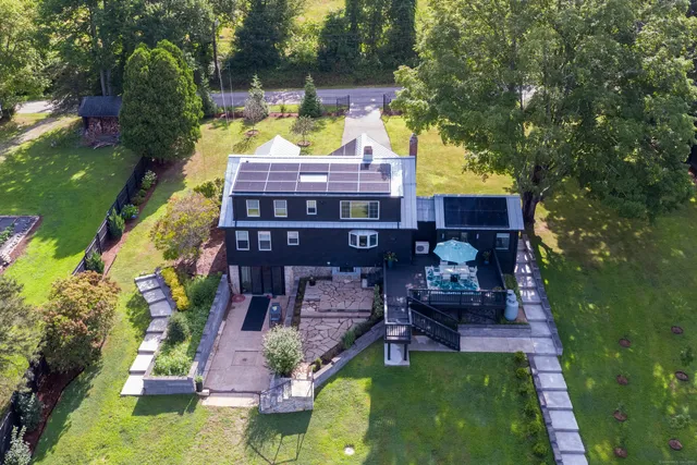 an aerial view of a house with swimming pool a yard and lake view