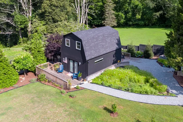 an aerial view of a house with a garden and large trees