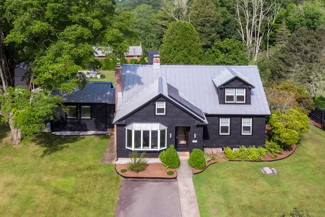 an aerial view of a house with swimming pool and a yard