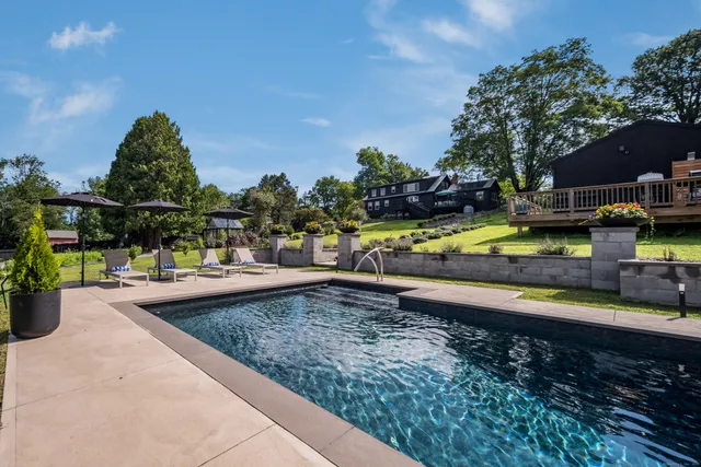 a view of a swimming pool with a patio and a garden