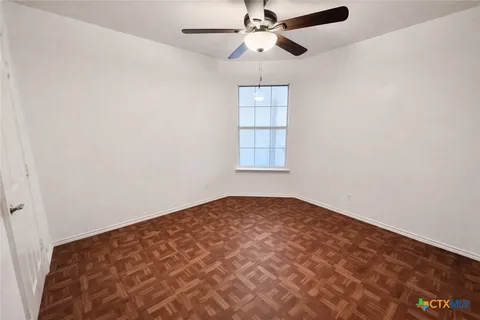 an empty room with windows and fan