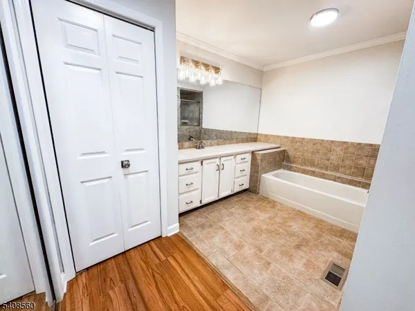 a bathroom with a tub sink and mirror