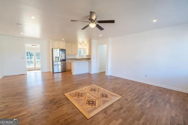 a kitchen with kitchen island wooden floors appliances and cabinets