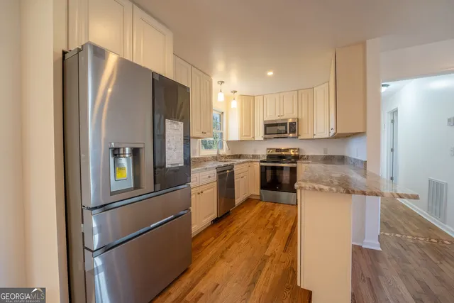 a kitchen with granite countertop cabinets stainless steel appliances and a sink