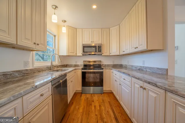 a kitchen with granite countertop a stove sink and microwave
