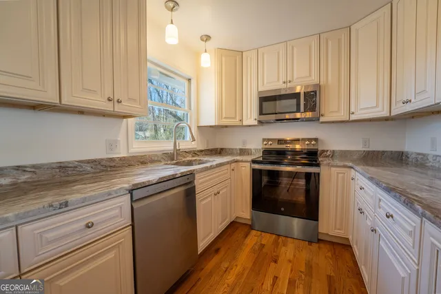 a view of a kitchen with a sink and a refrigerator