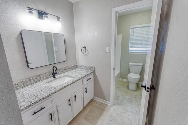 a bathroom with a granite countertop sink and a mirror