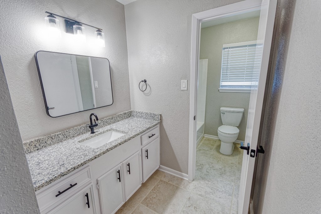 7017 Keystone Drive Corpus Christi, TX 78413 - Photo 15 of 21 a bathroom with a granite countertop sink and a mirror