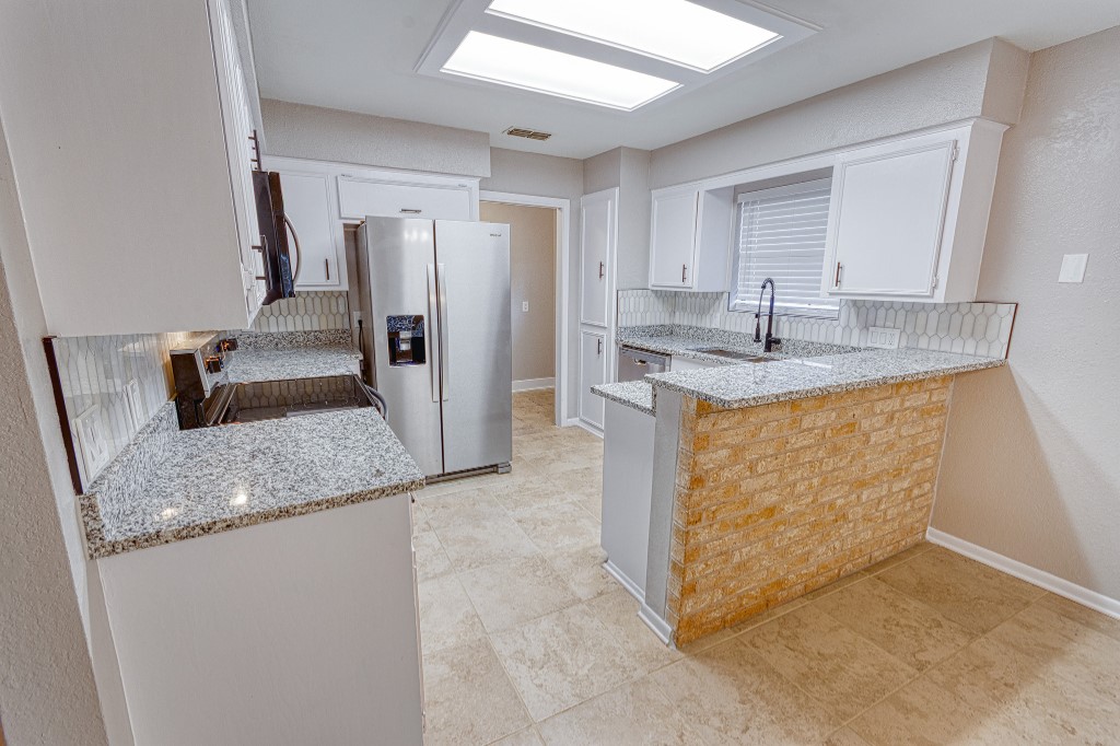 7017 Keystone Drive Corpus Christi, TX 78413 - Photo 3 of 21 a kitchen with stainless steel appliances granite countertop a sink stove and refrigerator