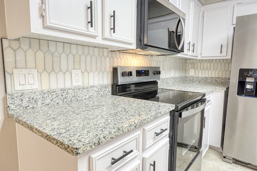 7017 Keystone Drive Corpus Christi, TX 78413 - Photo 4 of 21 a kitchen with stainless steel appliances granite countertop a sink stove and microwave