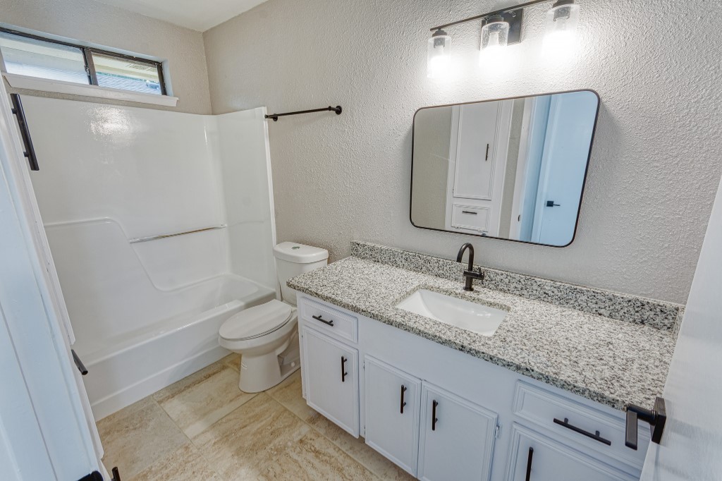 7017 Keystone Drive Corpus Christi, TX 78413 - Photo 10 of 21 a bathroom with a granite countertop sink toilet and shower