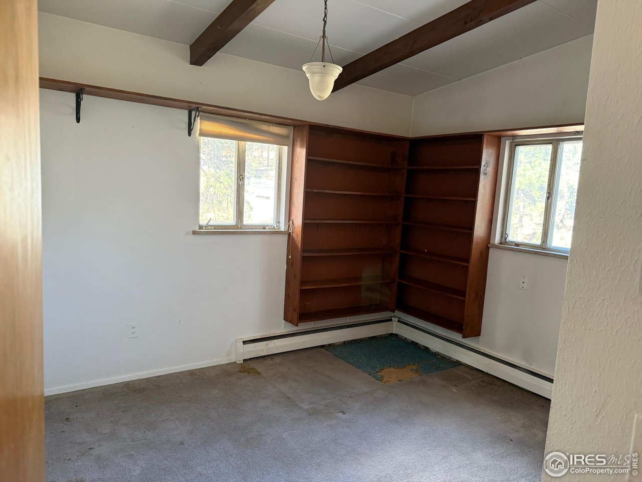 358 Kelly Road East Boulder, CO 80302 - Photo 8 of 16 a view of an empty room with a fireplace and a window