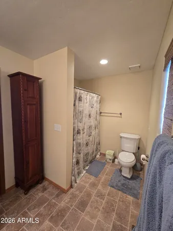 a bathroom with a toilet and a shower