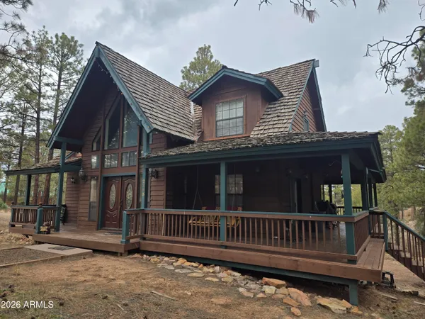 a view of a house with wooden fence and a porch