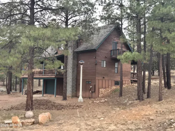 a view of a house with a yard and large tree