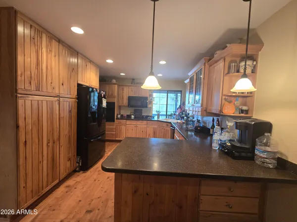 a kitchen with stainless steel appliances granite countertop a sink refrigerator and cabinets
