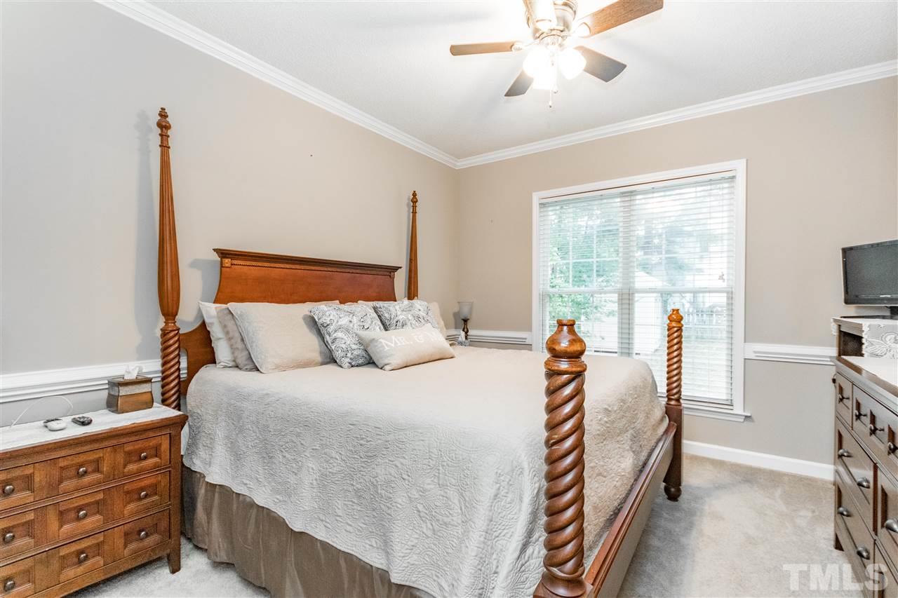 1913 Crag Burn Lane Raleigh, NC 27604 - Photo 23 of 29 a bedroom with a bed and a chandelier