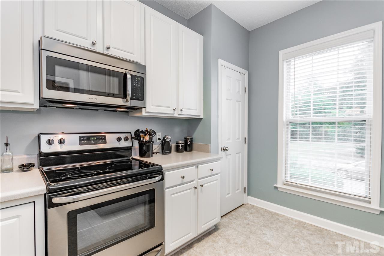 1913 Crag Burn Lane Raleigh, NC 27604 - Photo 24 of 29 a kitchen with stainless steel appliances granite countertop white cabinets and a stove top oven