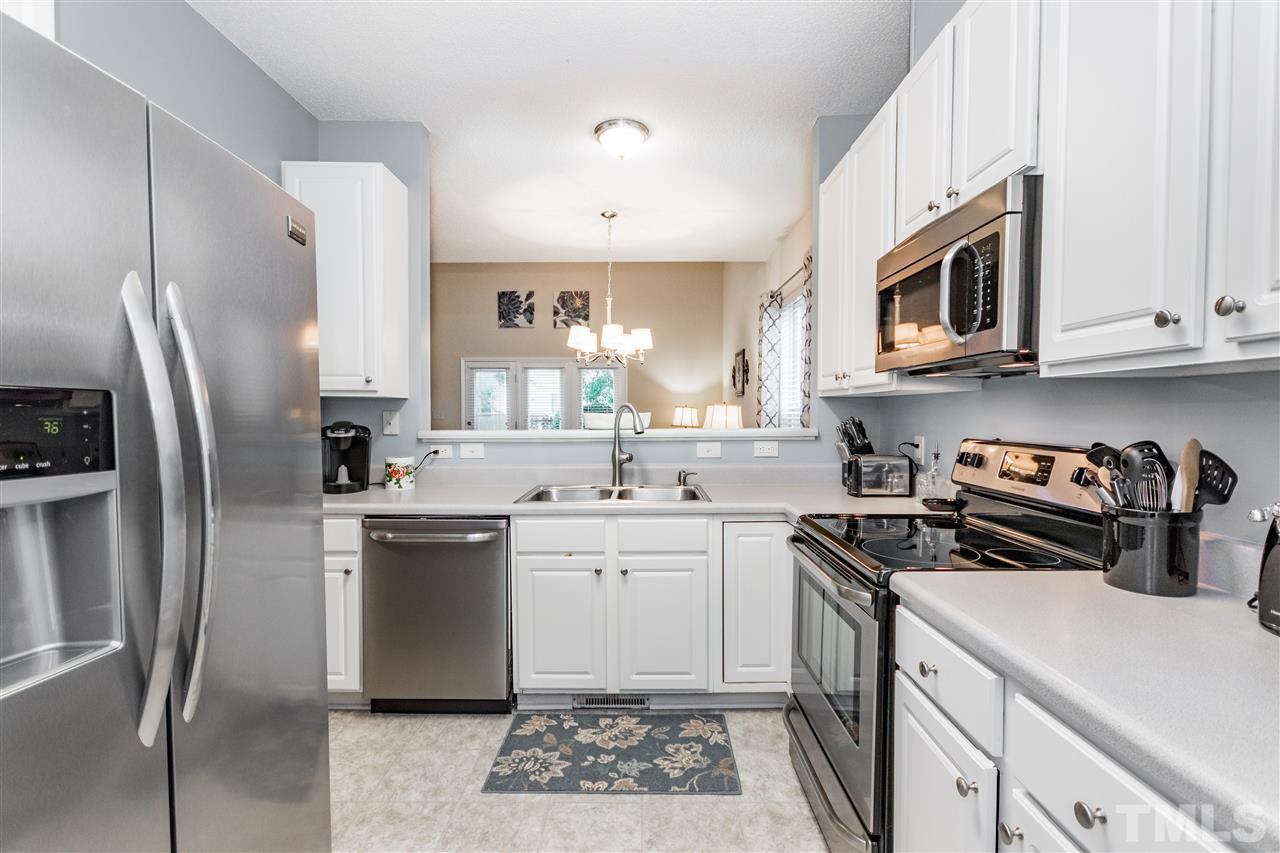 1913 Crag Burn Lane Raleigh, NC 27604 - Photo 4 of 29 a kitchen with stainless steel appliances granite countertop a sink stove refrigerator and cabinets