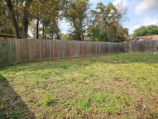 a view of garden with wooden fence