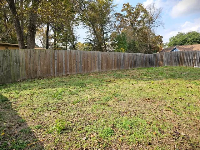 a view of garden with wooden fence