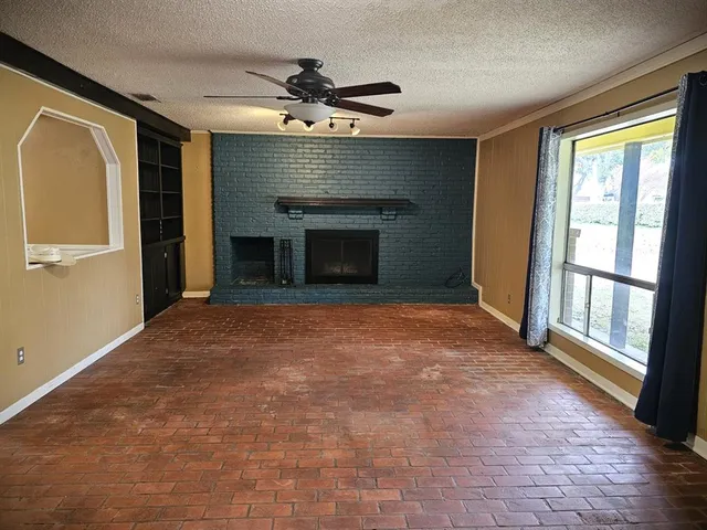 a view of an empty room with a fireplace and a window
