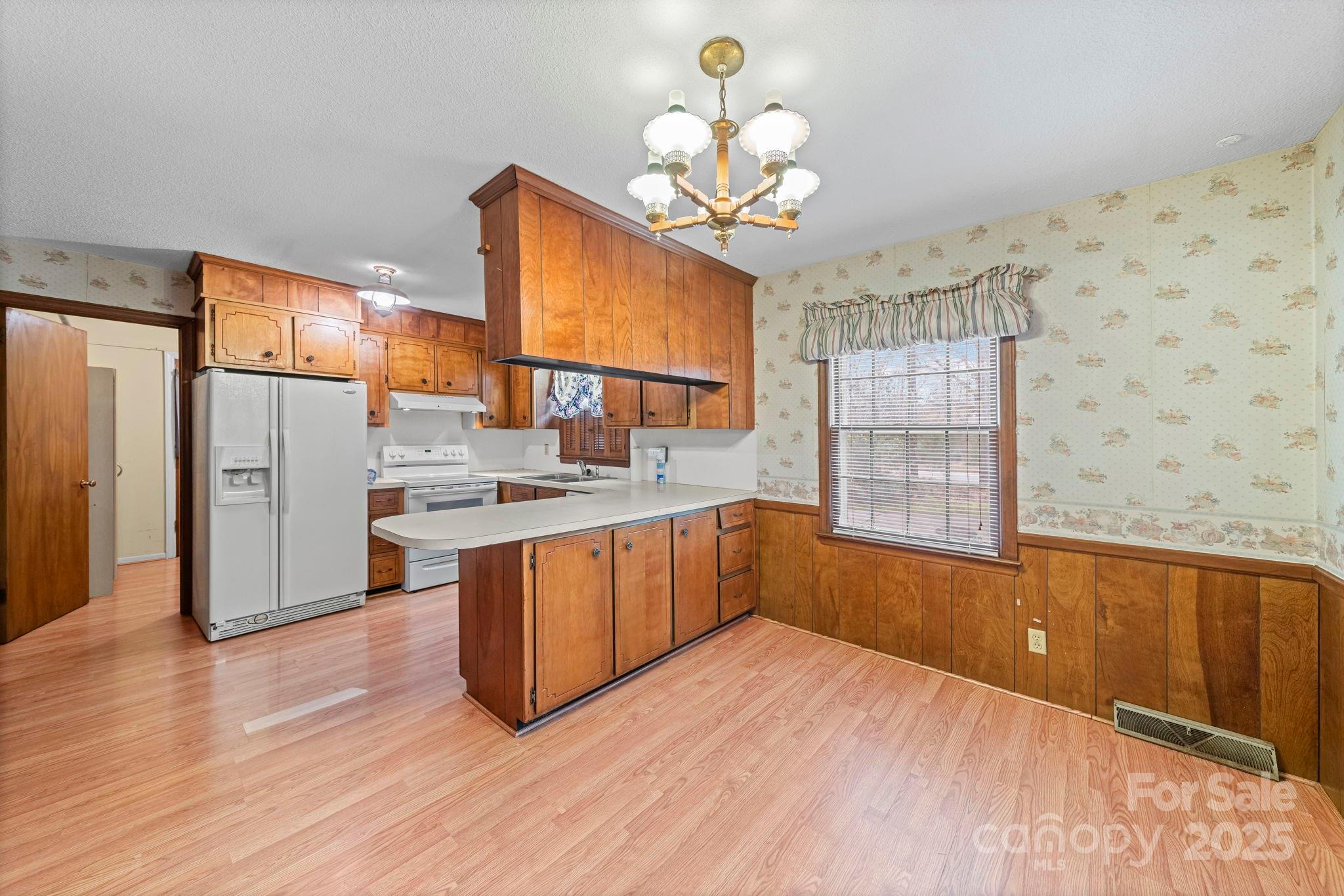 1902 Shady Lane Monroe, NC 28110 - Photo 12 of 36 a kitchen with stainless steel appliances wooden floor and a refrigerator