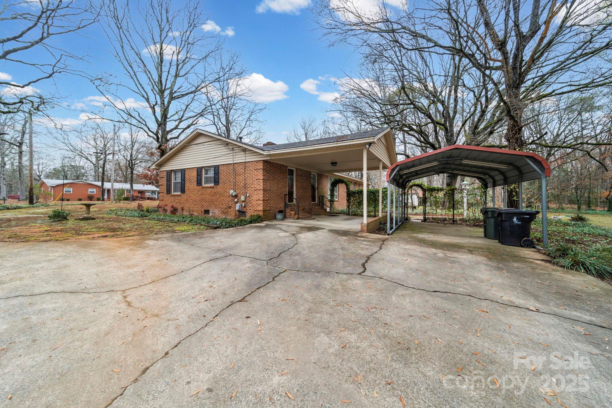 1902 Shady Lane Monroe, NC 28110 - Photo 31 of 36 a view of a white house with a table and chairs under an umbrella