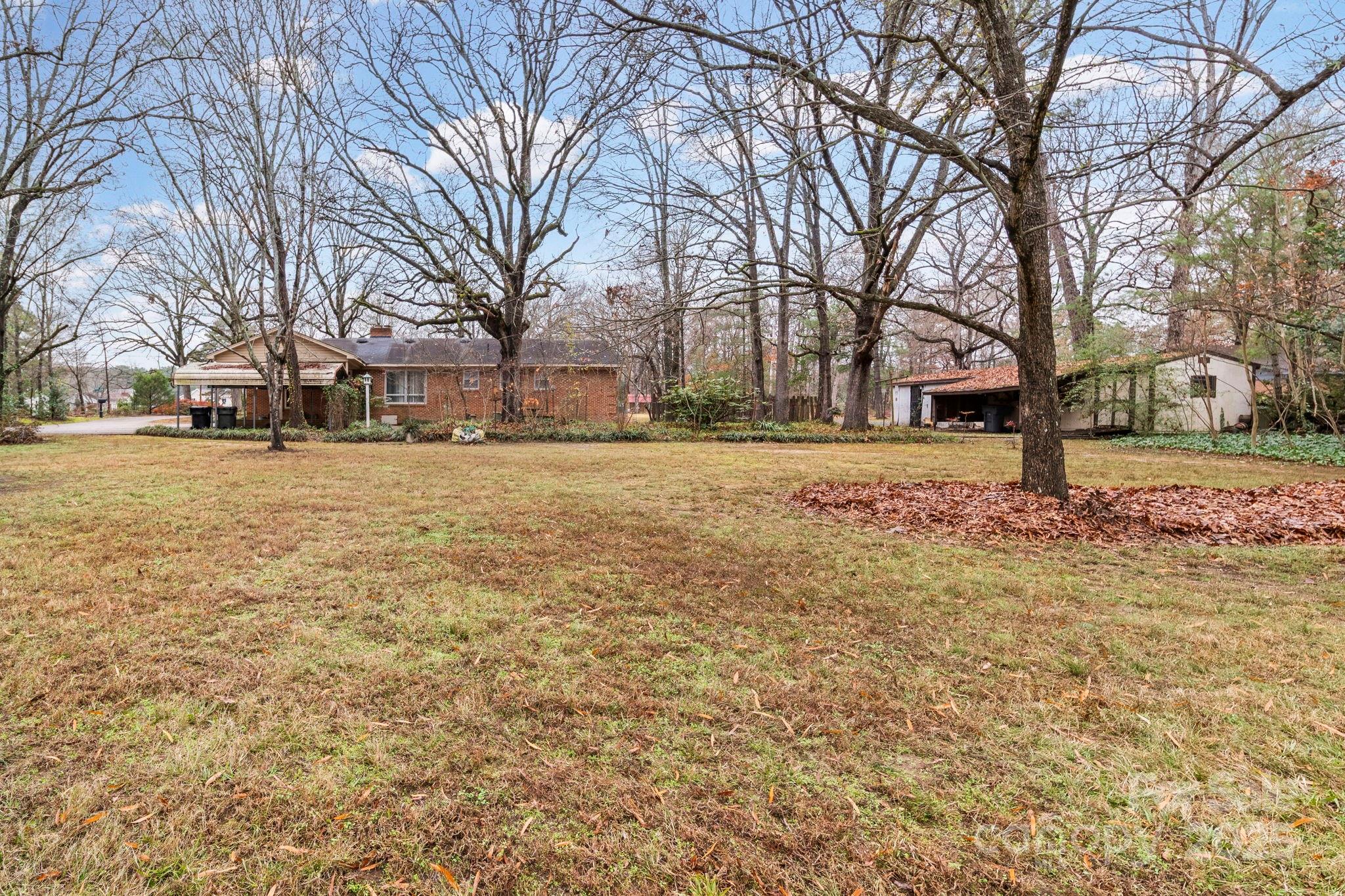 1902 Shady Lane Monroe, NC 28110 - Photo 36 of 36 a brick house with trees in front of it