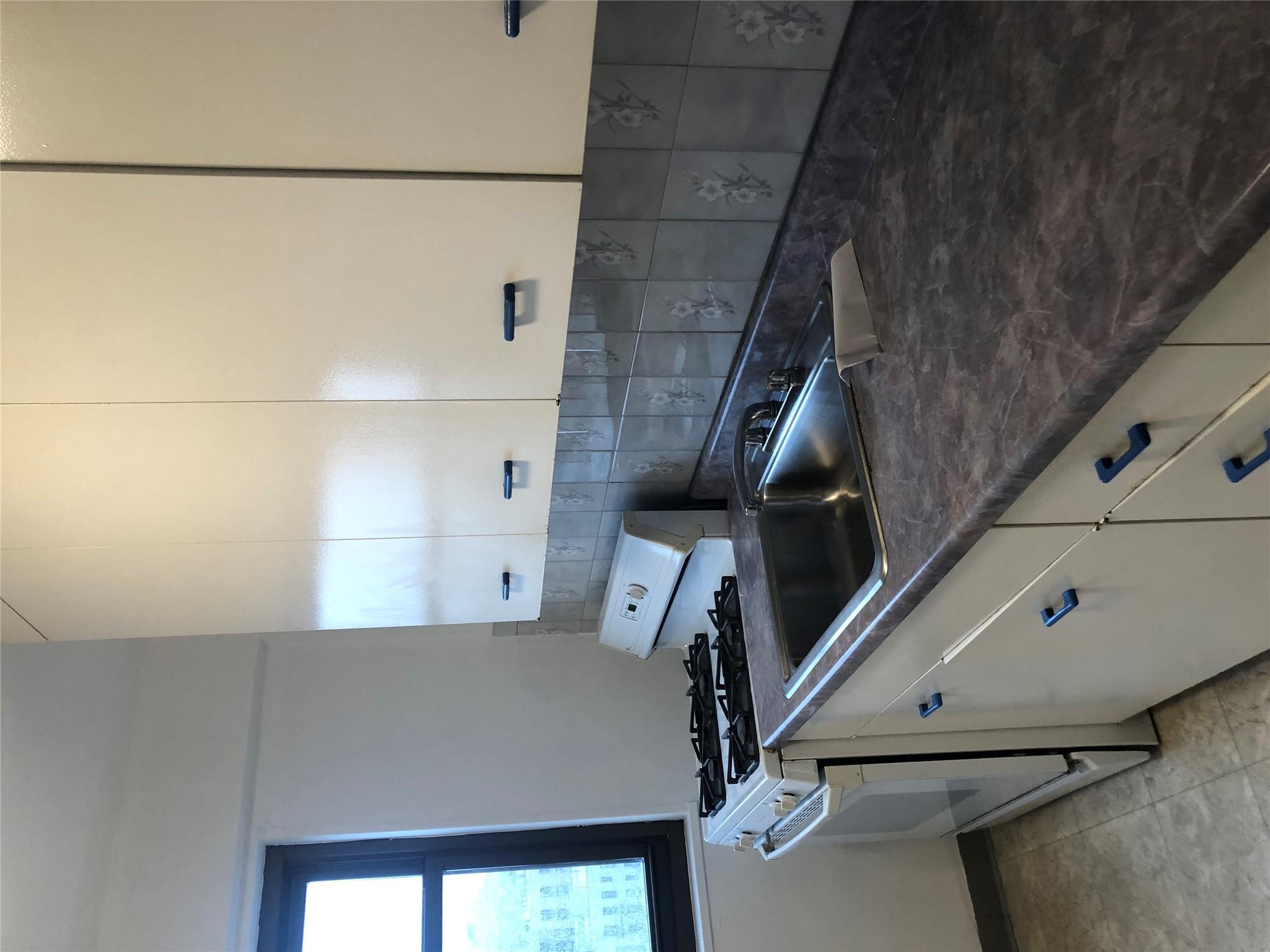 21-80 33rd Road, Unit 10A Queens, NY 11106 - Photo 8 of 14 a kitchen with granite countertop a sink and a stove