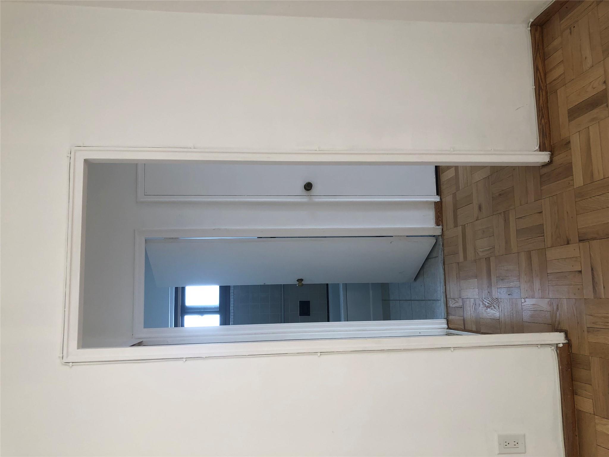 21-80 33rd Road, Unit 10A Queens, NY 11106 - Photo 10 of 14 a view of a hallway with a white cabinet and a refrigerator