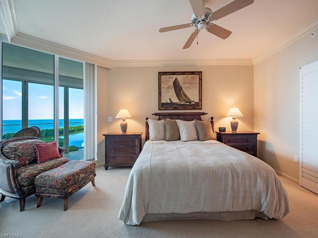 60 Seagate Drive, Unit 904 Naples, FL 34103 - Photo 13 of 35 a bedroom with a bed and large windows