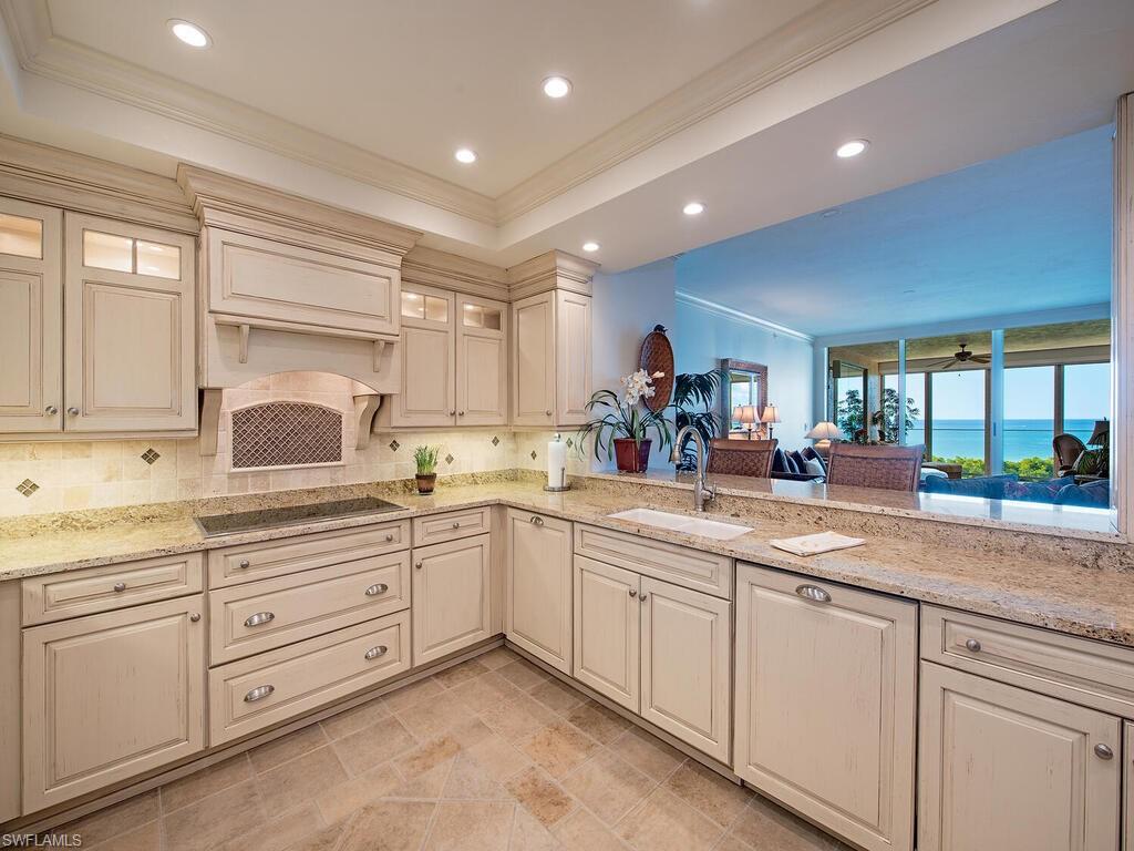 60 Seagate Drive, Unit 904 Naples, FL 34103 - Photo 10 of 35 a kitchen with sink and cabinets