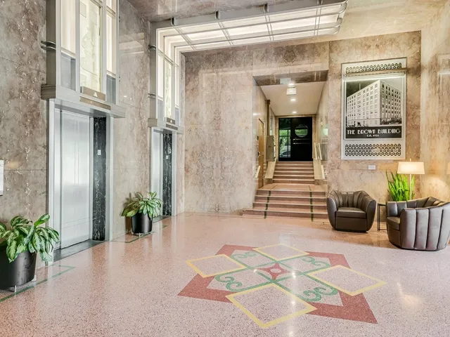 a lobby with furniture and potted plants