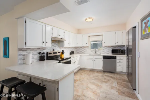 a kitchen with a sink white cabinets and white appliances