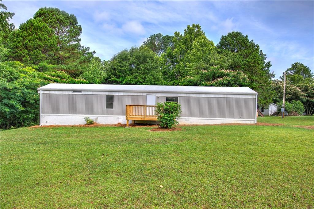a view of a house with backyard and a tree