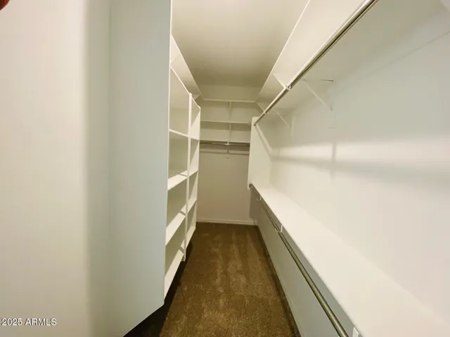 a view of patio with chairs and table under an umbrella with a barbeque