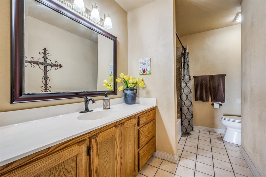778 County Road 3141 Decatur, TX 76234 - Photo 20 of 25 a bathroom with a sink a toilet and a mirror