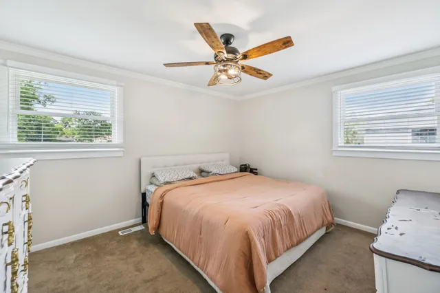 a bedroom with a bed and a chandelier fan