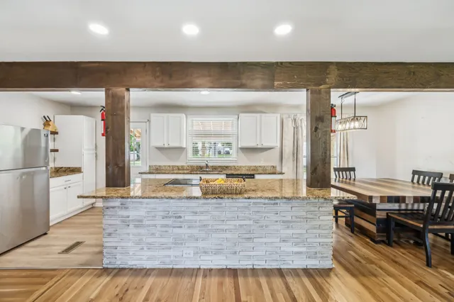 a kitchen with stainless steel appliances granite countertop a sink stove and wooden floor