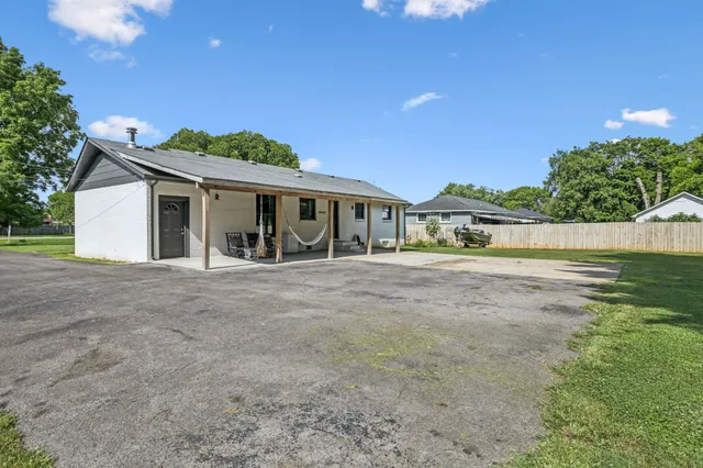 a view of a patio with table and chairs under an umbrella with a patio