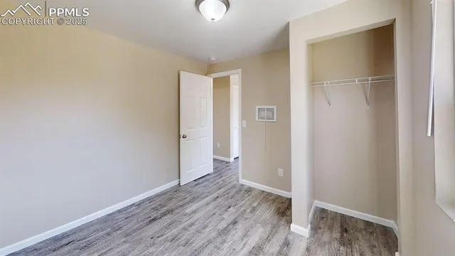 a view of an empty room with wooden floor