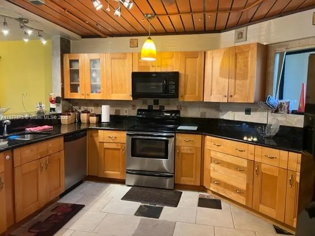 a kitchen with stainless steel appliances granite countertop a stove sink and cabinets