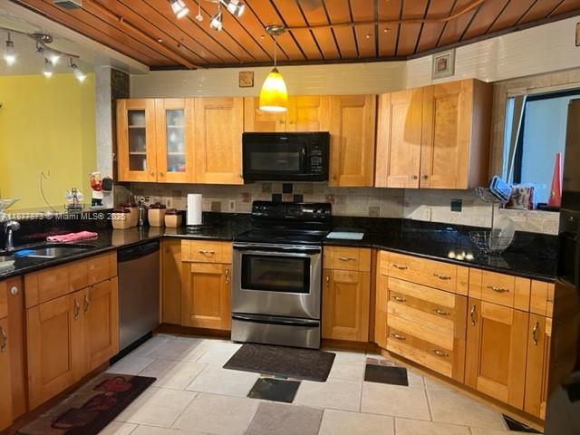600 Uno Lago Drive, Unit 302 Juno Beach, FL 33408 - Photo 2 of 11 a kitchen with stainless steel appliances granite countertop a stove sink and cabinets