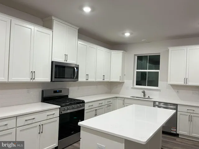 a kitchen with a sink a stove and cabinets
