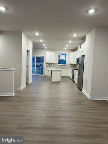 a view of kitchen dining table wooden floor and a refrigerator