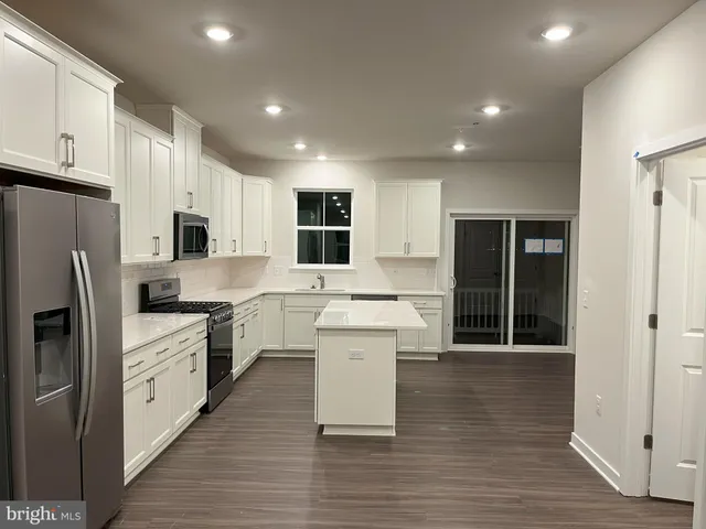 a large kitchen with stainless steel appliances lots of counter space and wooden floor