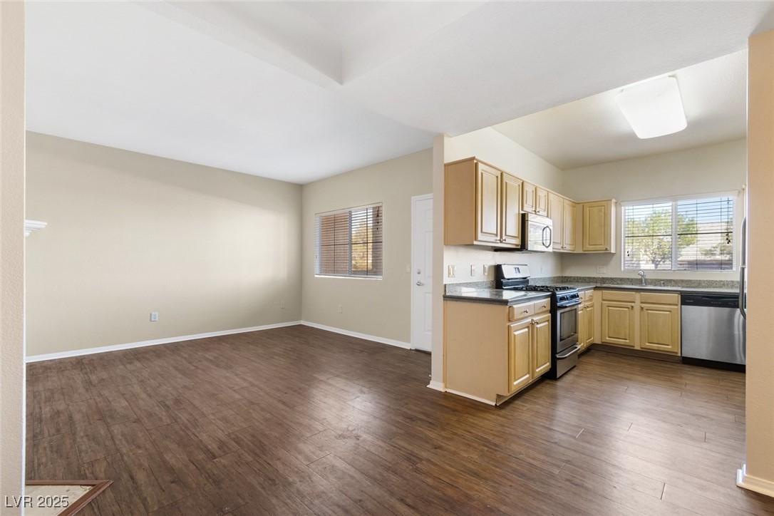 5250 South Rainbow Boulevard, Unit 1097 Las Vegas, NV 89118 - Photo 10 of 10 Kitchen with light brown cabinetry, appliances with stainless steel finishes, dark wood-style floors, and open floor plan