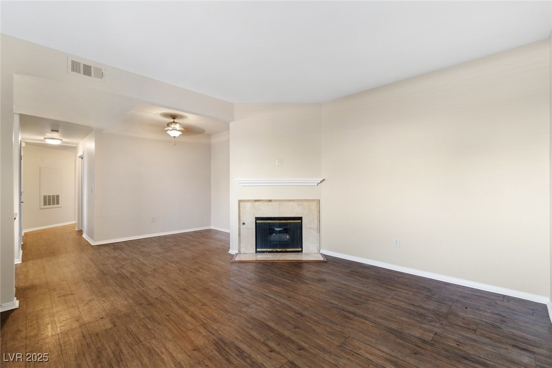 5250 South Rainbow Boulevard, Unit 1097 Las Vegas, NV 89118 - Photo 9 of 10 Unfurnished living room with a fireplace and dark wood-style flooring